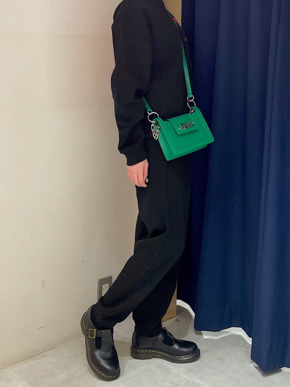 ブラック系のスウェット、グリーン系のショルダーバッグ、ブラック系のスウェットパンツを着用したレディースの冬コーディネートの3枚目の写真