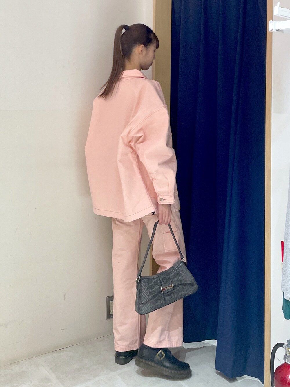 ブラック系のハンドバッグ、ピンク系のパンツ、ブラック系のTシャツ/カットソーを着用したレディースの冬コーディネートの4枚目の写真