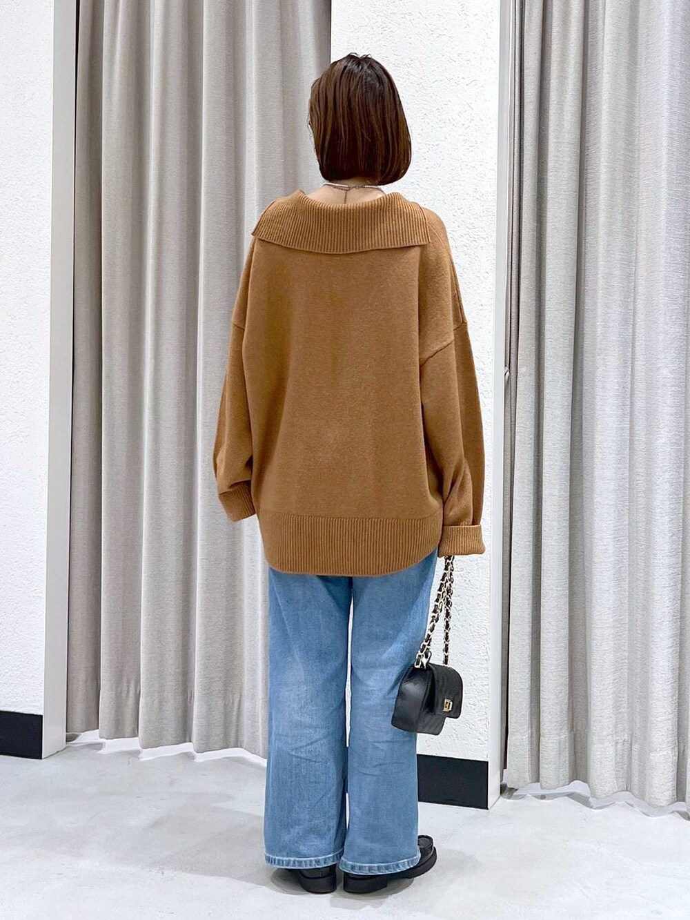 ブルー系のデニムパンツ、イエロー系のニット/セーター、ブラック系のショルダーバッグを着用したレディースの冬コーディネートの7枚目の写真