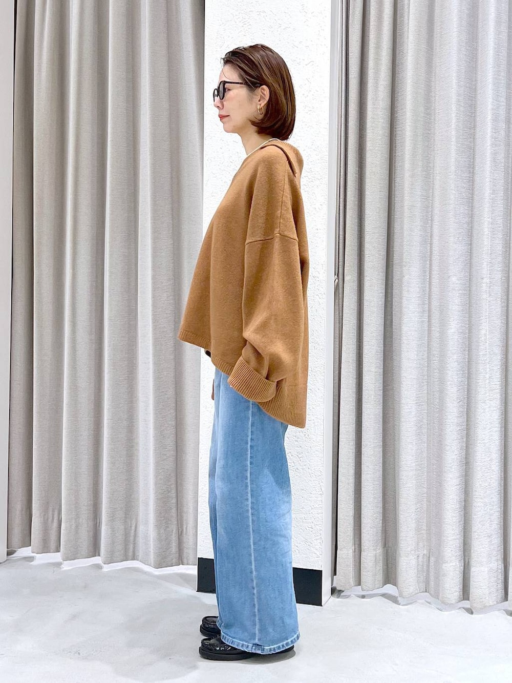 ブルー系のデニムパンツ、イエロー系のニット/セーター、ブラック系のショルダーバッグを着用したレディースの冬コーディネートの6枚目の写真