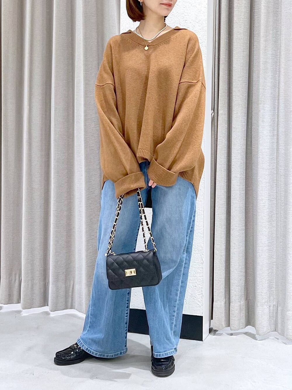 ブルー系のデニムパンツ、イエロー系のニット/セーター、ブラック系のショルダーバッグを着用したレディースの冬コーディネートの3枚目の写真