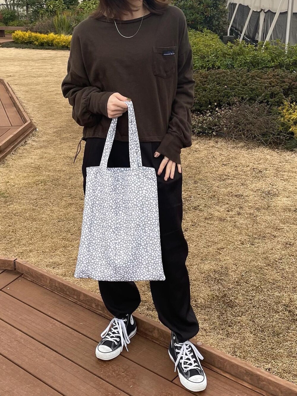 グレー系のエコバッグ/サブバッグ、ブラック系のその他パンツ、ブラック系のスニーカーを着用したレディースの冬コーディネートの2枚目の写真
