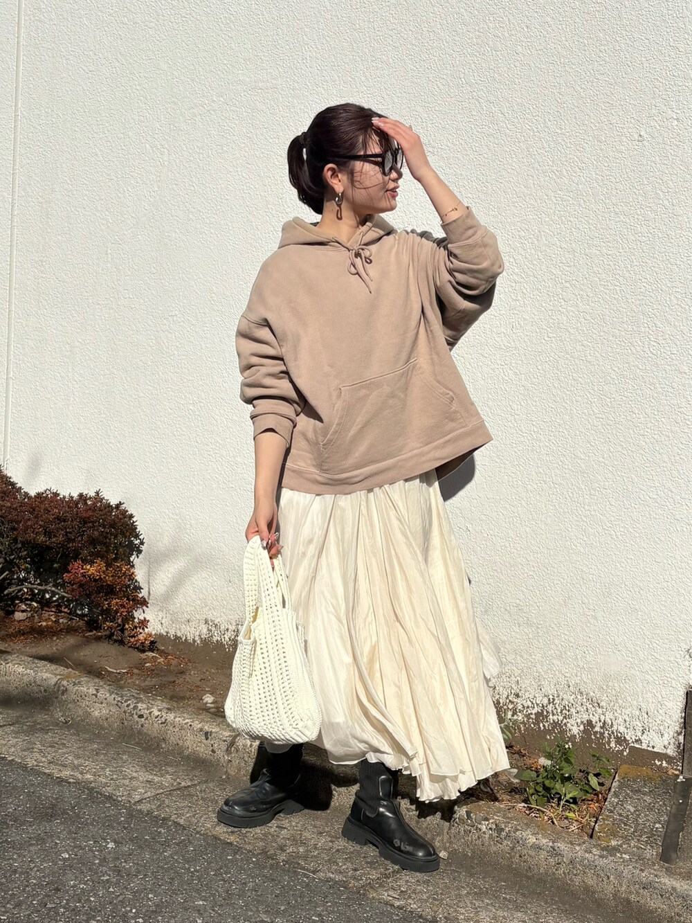 ホワイト系のハンドバッグを着用したレディースの冬コーディネートの2枚目の写真