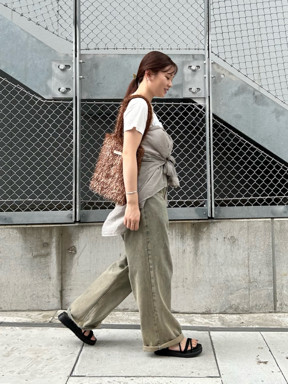 ブラウン系のトートバッグ、ホワイト系のTシャツ/カットソー、グレー系のシャツ/ブラウスを着用したレディースの夏コーディネートの4枚目の写真