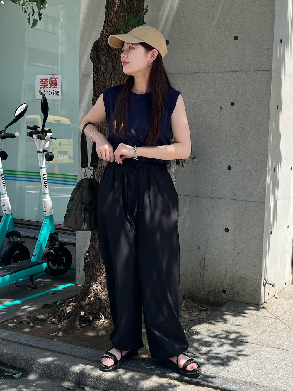グリーン系のトートバッグ、ブルー系のTシャツ/カットソー、ブラック系のカーゴパンツを着用したレディースの夏コーディネートの3枚目の写真
