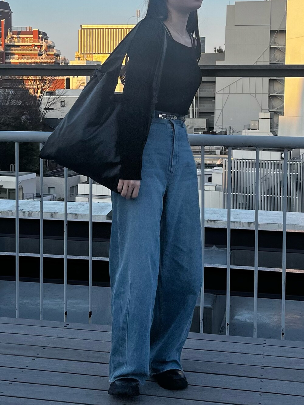 ブラック系のニット/セーター、ブルー系のデニムパンツ、ブラック系のトートバッグを着用したレディースの冬コーディネートの3枚目の写真