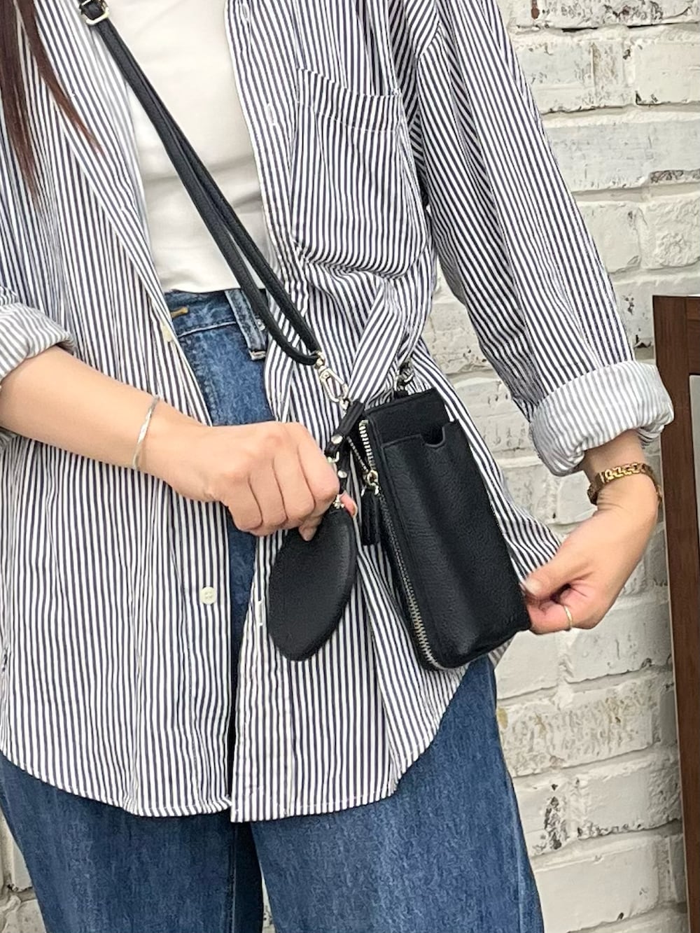 ブラック系のショルダーバッグ、ブラック系のシャツ/ブラウス、ホワイト系のキャミソールを着用したレディースの夏コーディネートの2枚目の写真
