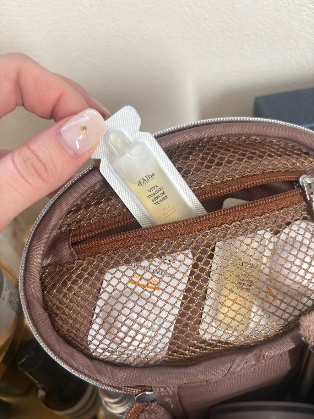 ブルー系のポーチを着用したレディースの春コーディネートの2枚目の写真