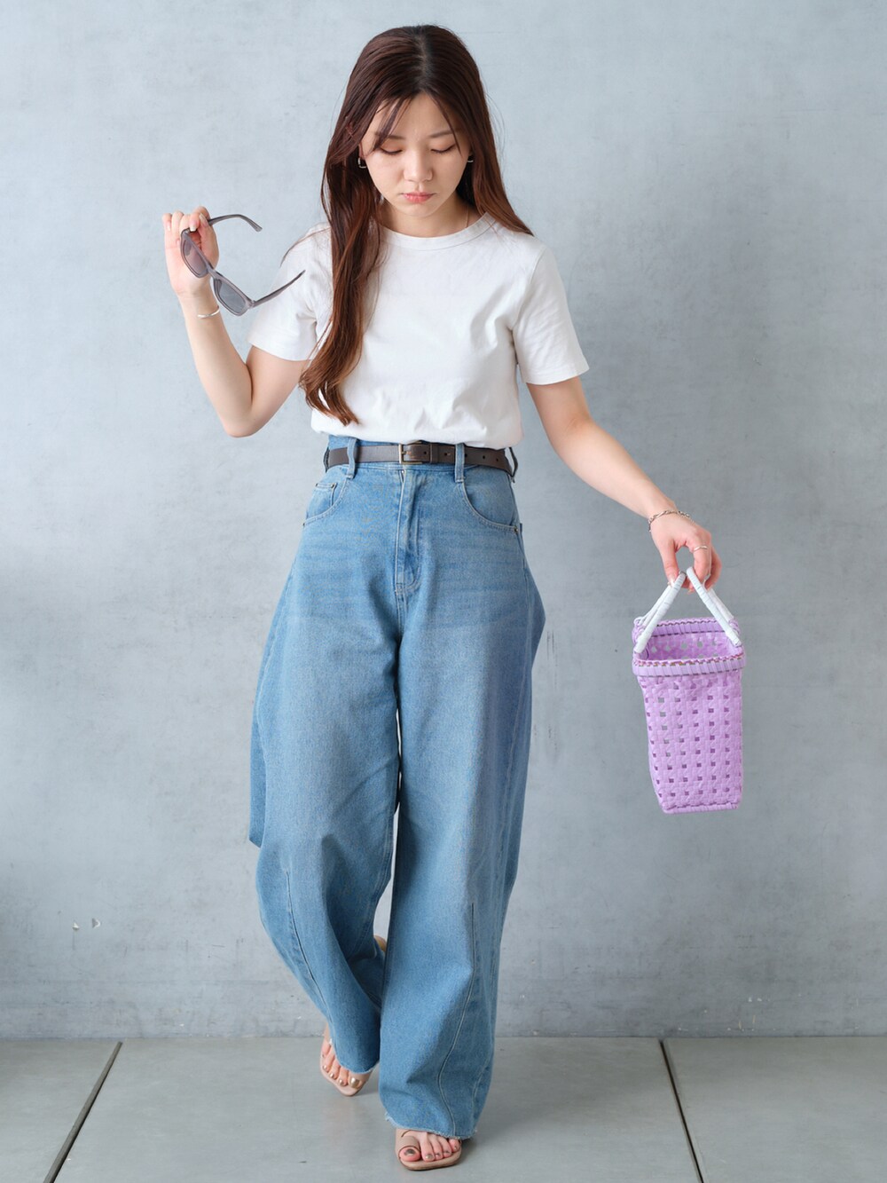 パープル系のかごバッグ、ホワイト系のTシャツ/カットソー、ブルー系のデニムパンツを着用したレディースの春コーディネートの2枚目の写真