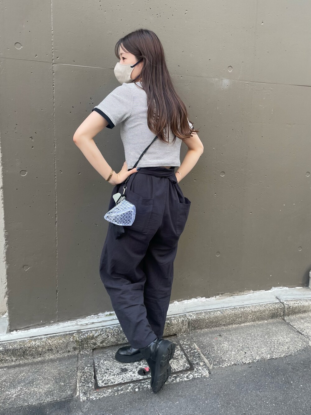 ブラック系のサロペット/オーバーオール、ブラック系のブーツ、ホワイト系のTシャツ/カットソーを着用したレディースの春コーディネートの2枚目の写真