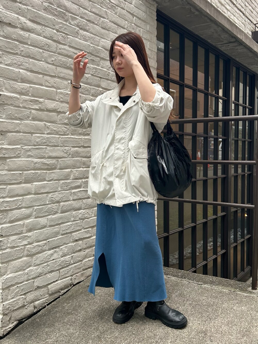 ブラック系のトートバッグ、ホワイト系のブルゾン、ブルー系のスカートを着用したレディースの春コーディネートの4枚目の写真