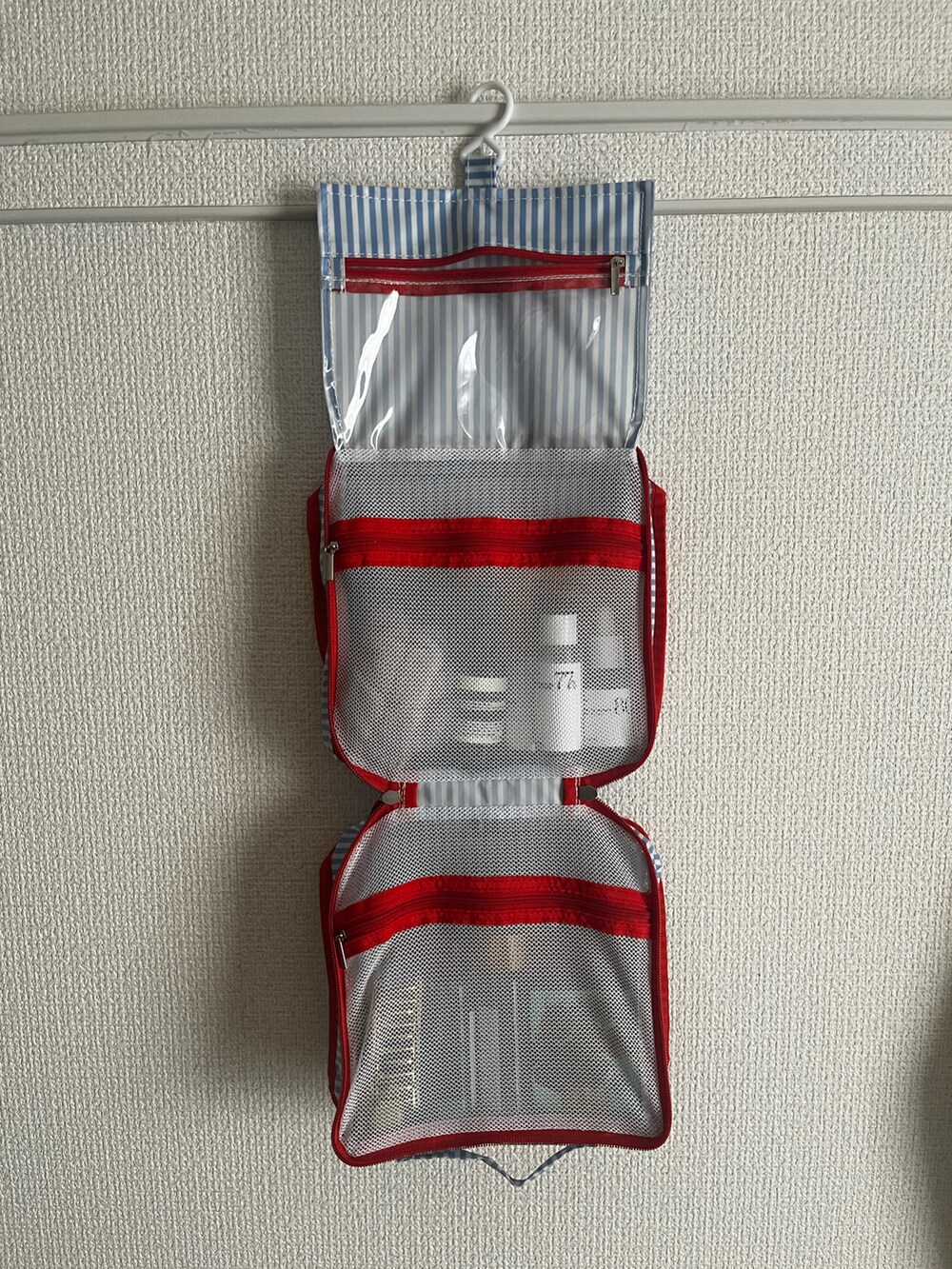 ブルー系のトラベルグッズを着用したレディースの夏コーディネートの2枚目の写真