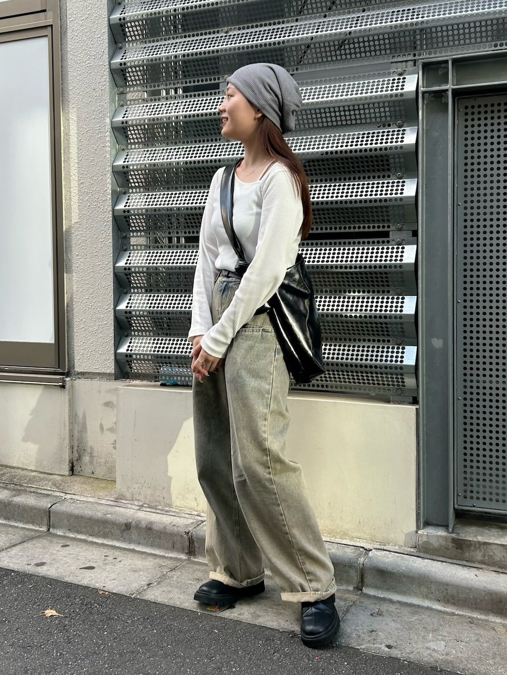 ブラック系のトートバッグ、ホワイト系のTシャツ/カットソー、ベージュ系のデニムパンツを着用したレディースの秋コーディネートの2枚目の写真