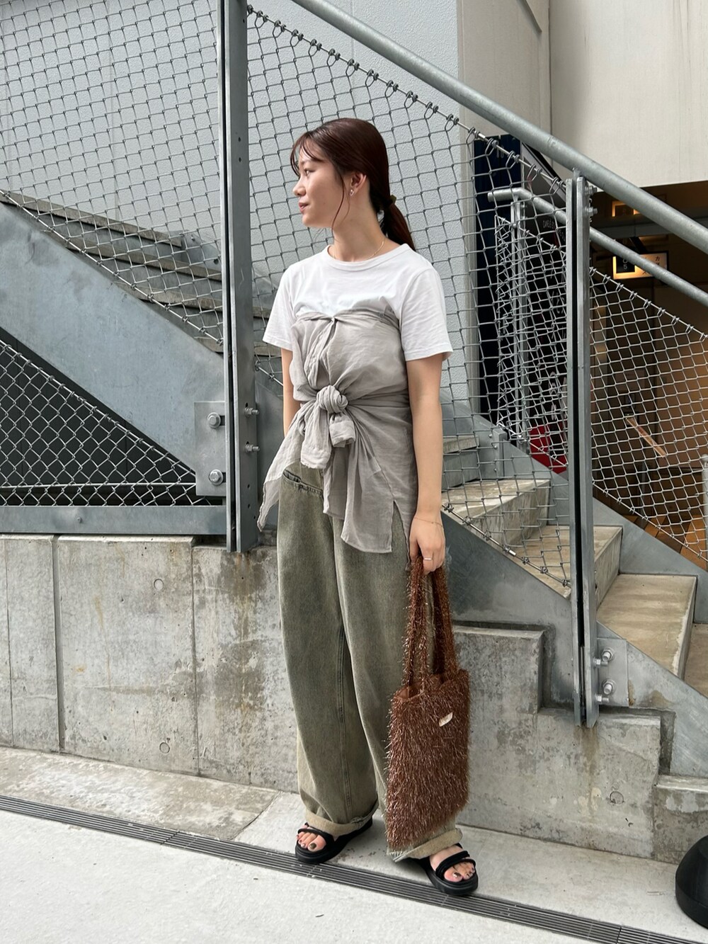 ブラウン系のトートバッグ、ホワイト系のTシャツ/カットソー、グレー系のシャツ/ブラウスを着用したレディースの夏コーディネートの2枚目の写真