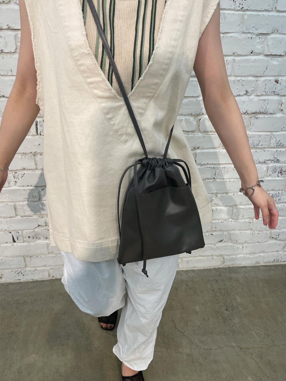 ホワイト系のベスト、グリーン系のタンクトップ、ホワイト系のその他パンツを着用したレディースの夏コーディネートの4枚目の写真