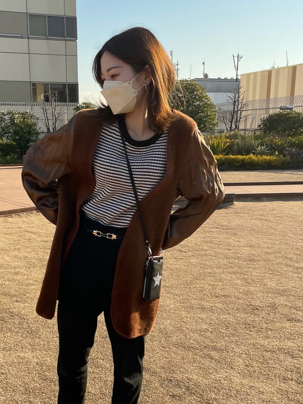ブラック系のその他パンツ、グレー系のスニーカー、ブラウン系のジャケット/アウターを着用したレディースの冬コーディネートの2枚目の写真