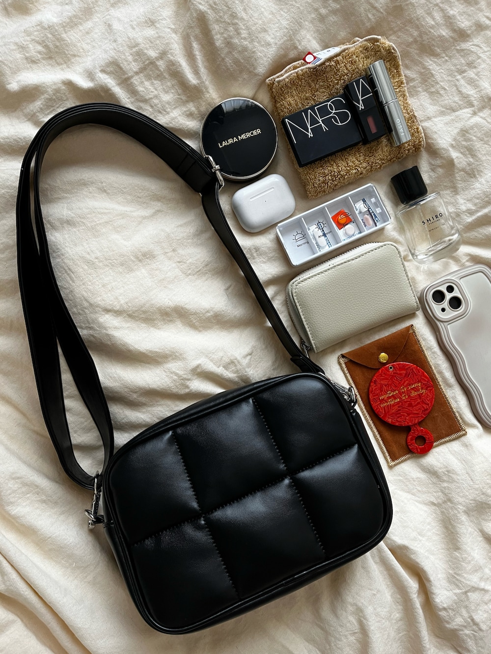 ブラック系のショルダーバッグ、オレンジ系の手鏡/メイクミラー、ホワイト系の財布を着用したレディースの秋コーディネートの2枚目の写真