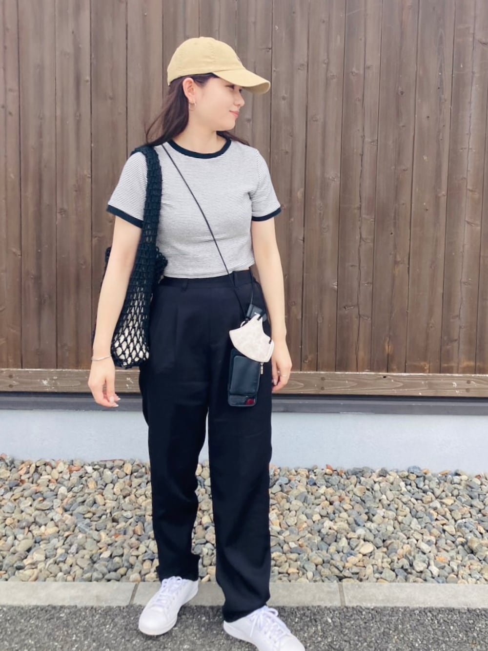 ブラック系のその他パンツ、ホワイト系のTシャツ/カットソー、ホワイト系のスニーカーを着用したレディースの春コーディネートの2枚目の写真