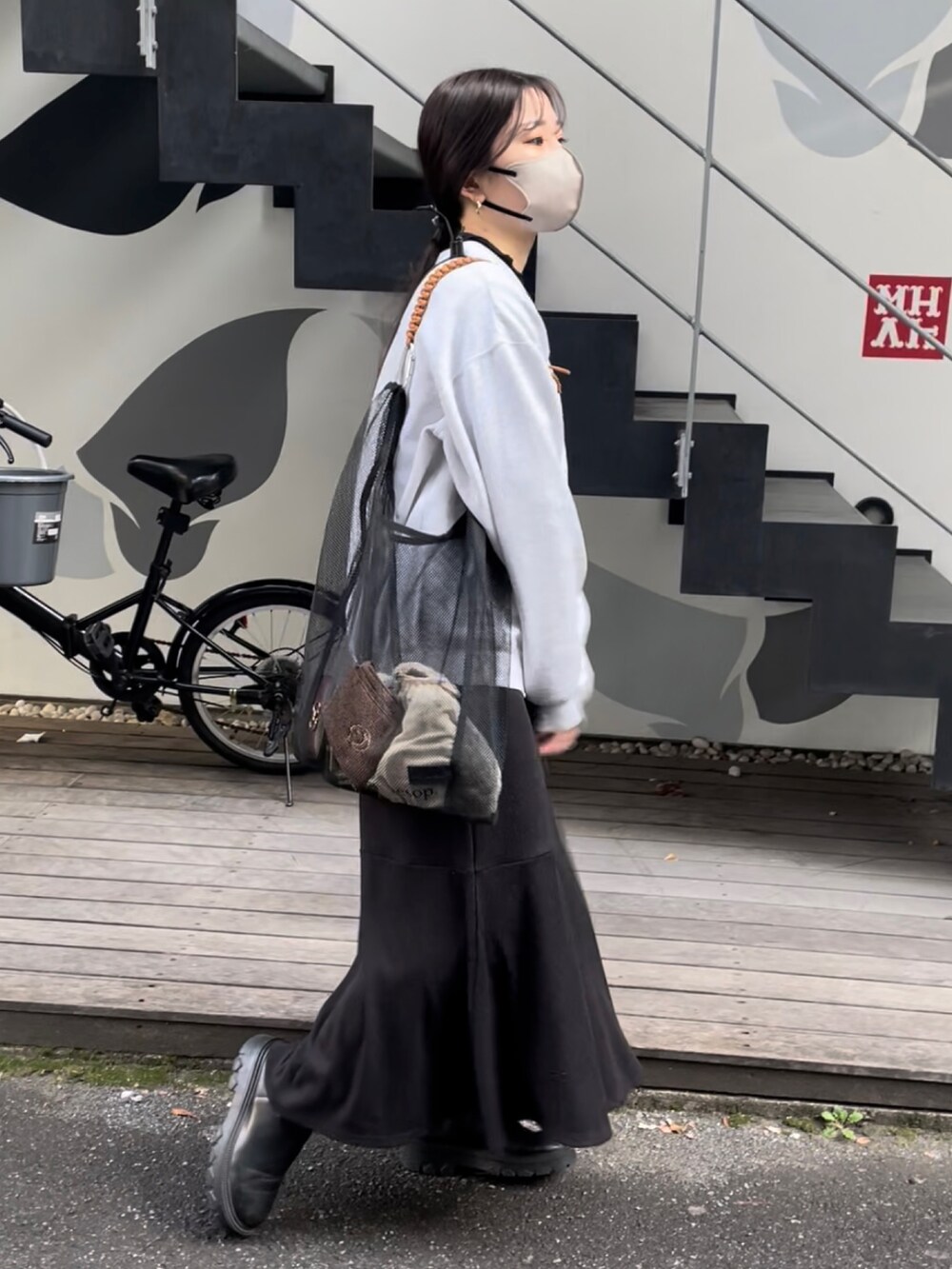 ブラック系のトートバッグ、グレー系のスウェット、ブラック系のTシャツ/カットソーを着用したレディースの冬コーディネートの2枚目の写真