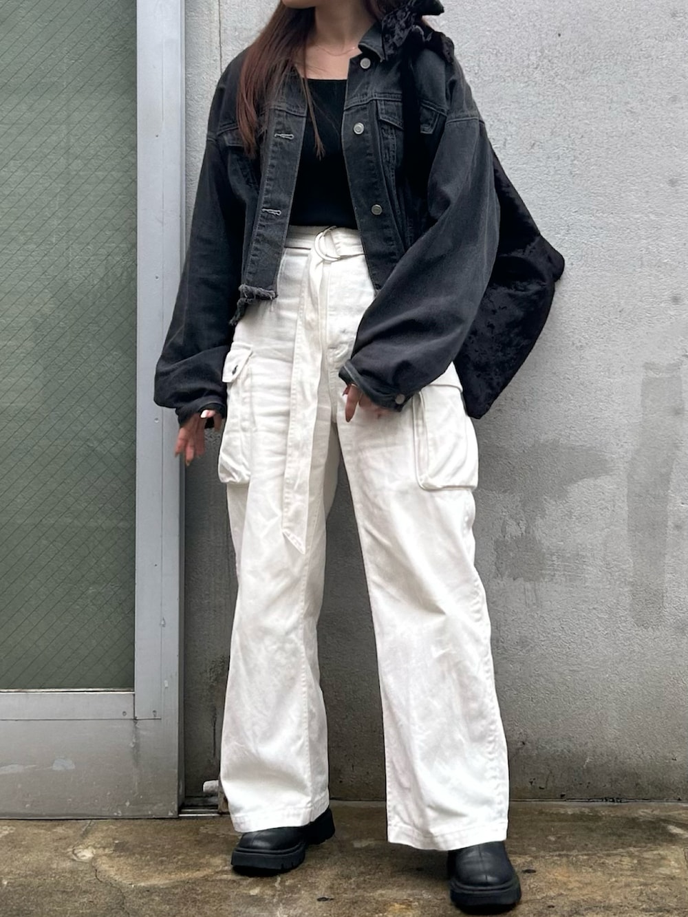 ブラック系のトートバッグ、ブラック系のデニムジャケット、ホワイト系のデニムパンツを着用したレディースの秋コーディネートの3枚目の写真