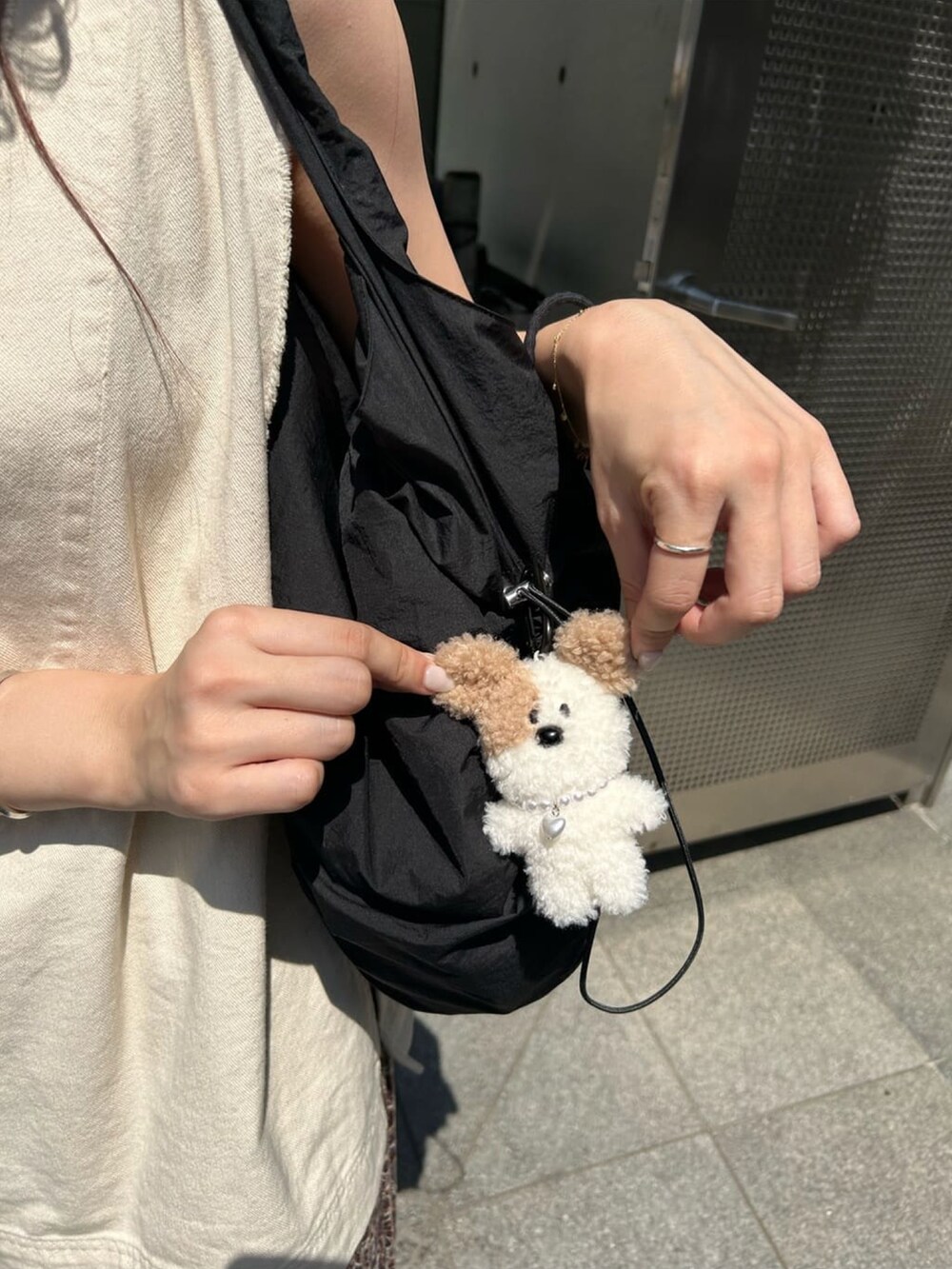 ブラック系のトートバッグ、ホワイト系のベスト、ブラウン系のその他パンツを着用したレディースの夏コーディネートの3枚目の写真