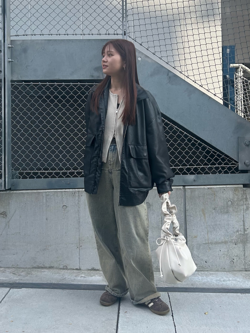 ホワイト系のトートバッグ、ブラック系のブルゾン、ホワイト系のニット/セーターを着用したレディースの冬コーディネートの3枚目の写真