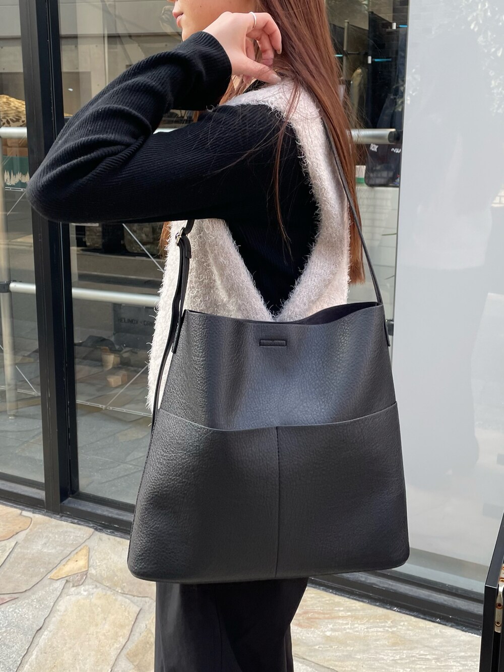 ブラック系のショルダーバッグ、グレー系のベスト、ブラック系のニット/セーターを着用したレディースの春コーディネートの3枚目の写真