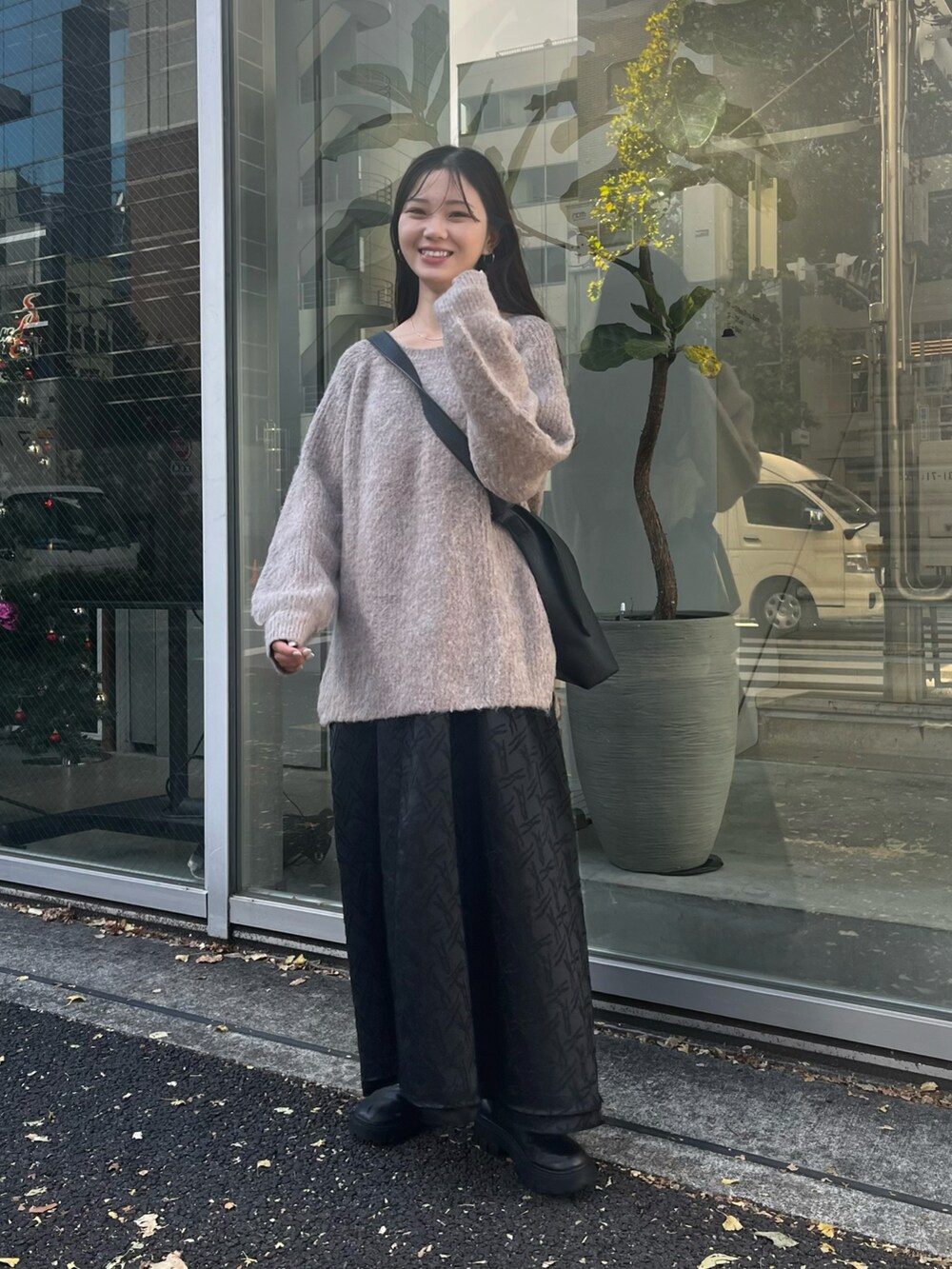 ブラック系のショルダーバッグ、ブラウン系のニット/セーター、ブラック系のワンピースを着用したレディースの秋コーディネートの2枚目の写真