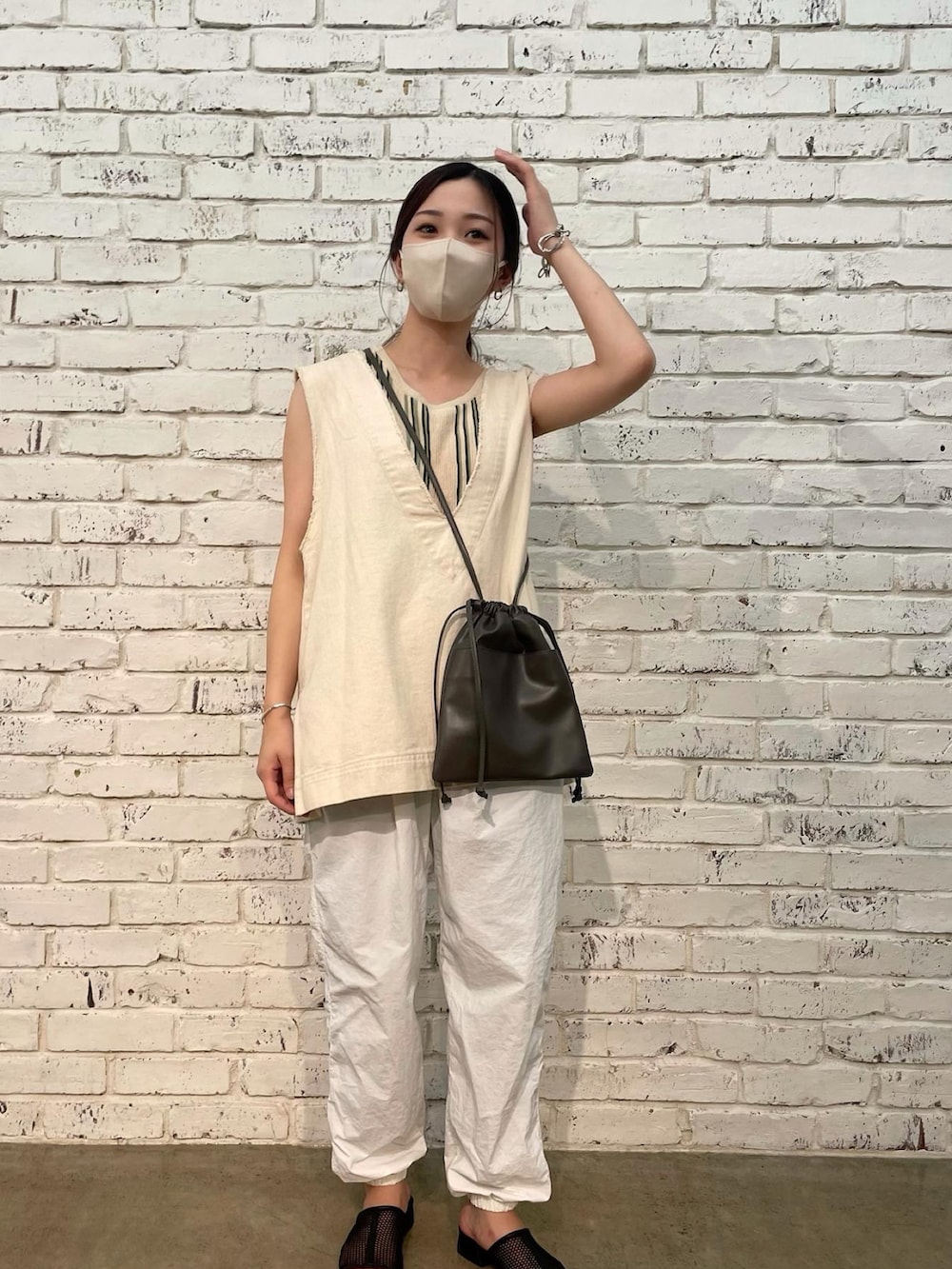 ホワイト系のベスト、グリーン系のタンクトップ、ホワイト系のその他パンツを着用したレディースの夏コーディネートの2枚目の写真