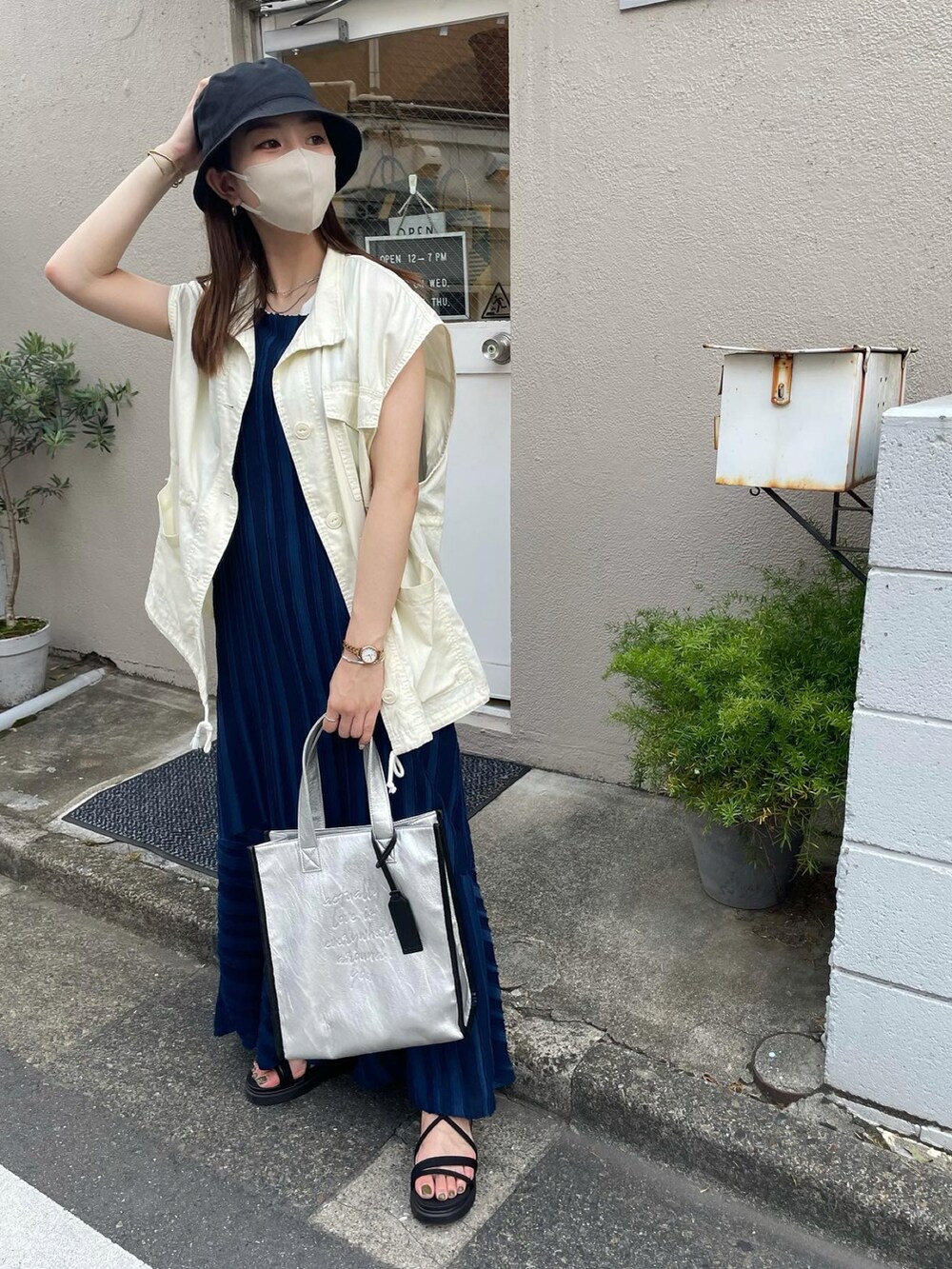 ホワイト系のベスト、ブルー系のワンピース、ブラック系のサンダルを着用したレディースの夏コーディネートの2枚目の写真