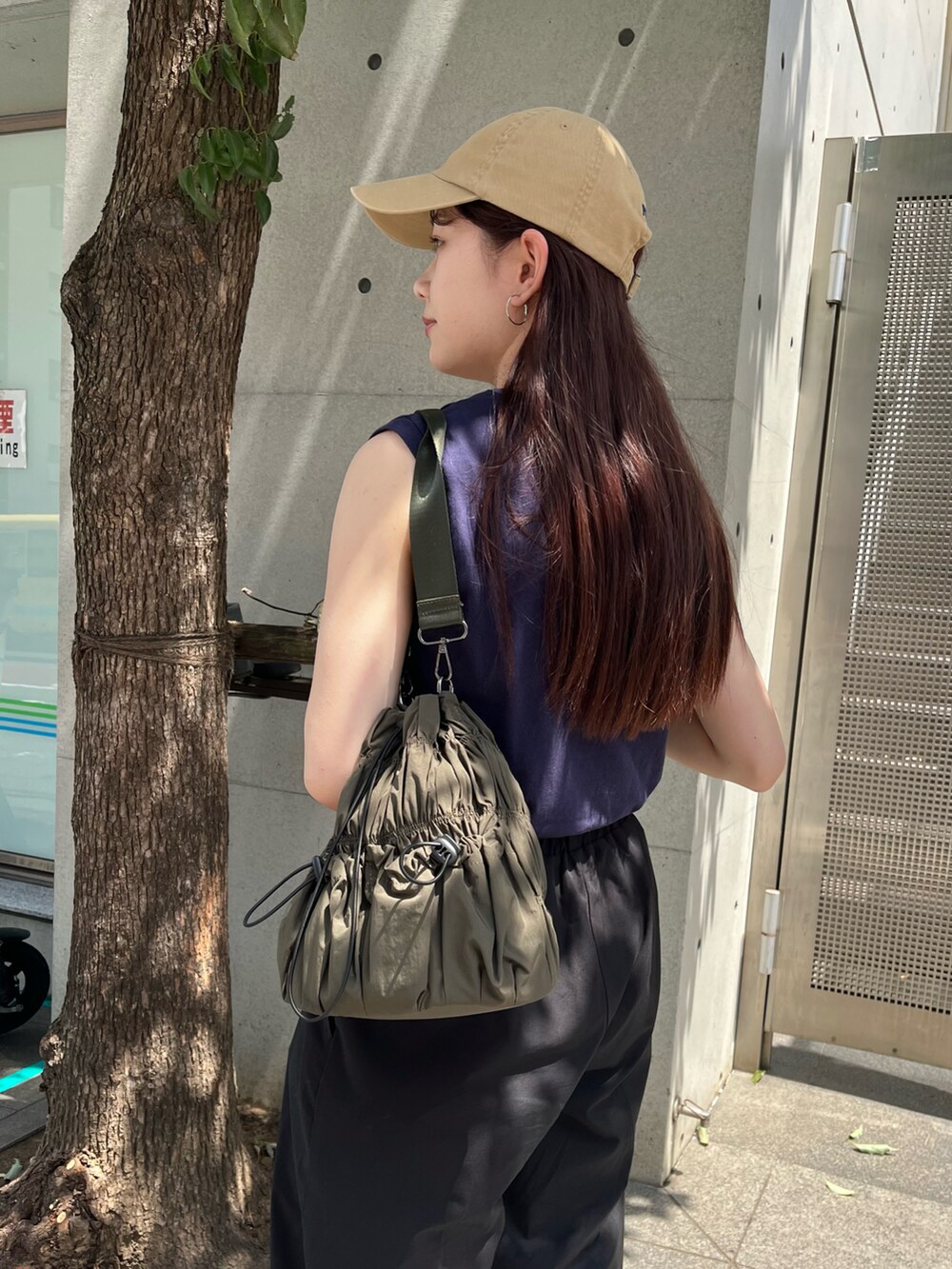 グリーン系のトートバッグ、ブルー系のTシャツ/カットソー、ブラック系のカーゴパンツを着用したレディースの夏コーディネートの2枚目の写真