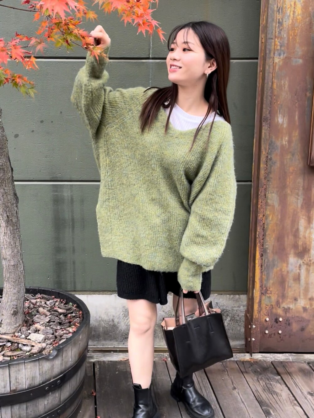 ブラック系のトートバッグ、グリーン系のニット/セーター、ブラック系のその他パンツを着用したレディースの秋コーディネートの2枚目の写真