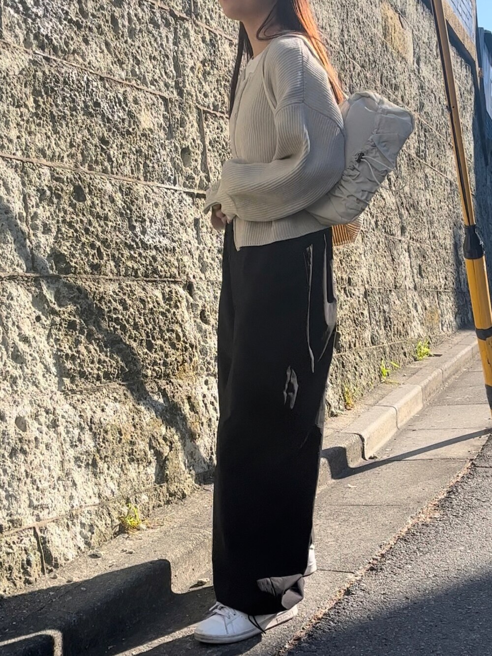 ホワイト系のトートバッグ、ホワイト系のニット/セーター、ブラック系のカーゴパンツを着用したレディースの冬コーディネートの2枚目の写真