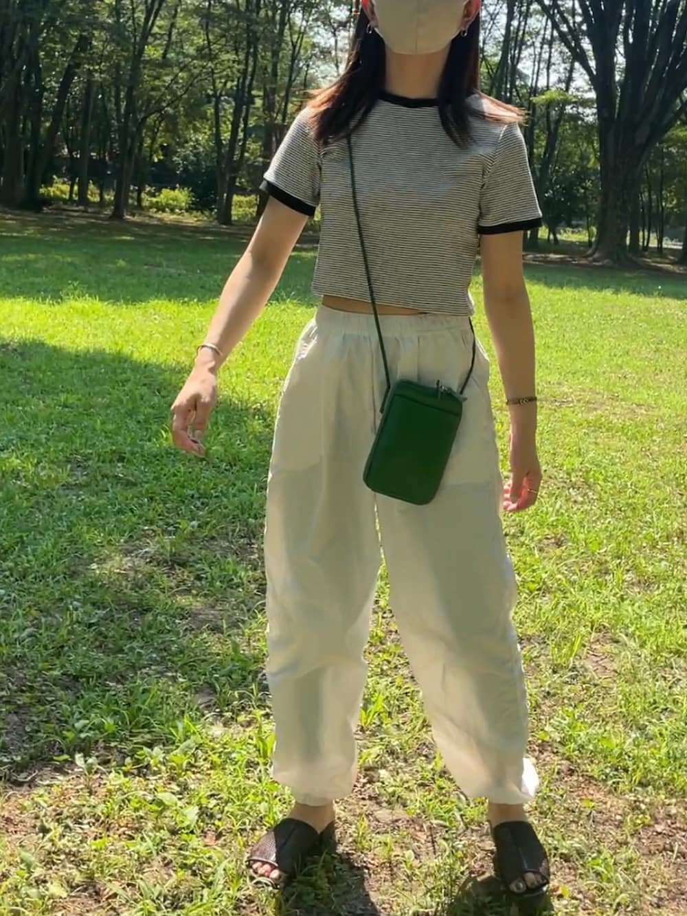 ホワイト系のTシャツ/カットソー、ホワイト系のその他パンツ、ブラック系のサンダルを着用したレディースの夏コーディネートの2枚目の写真