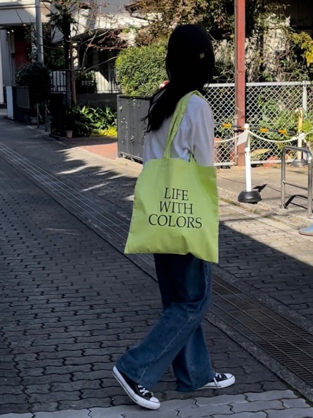 イエロー系のトートバッグを着用したレディースの春コーディネートの2枚目の写真