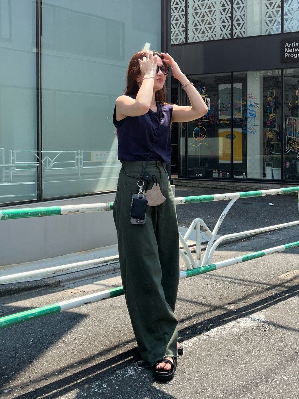 ブルー系のTシャツ/カットソー、グリーン系のデニムパンツ、ブラック系のスマホグッズを着用したレディースの夏コーディネートの3枚目の写真