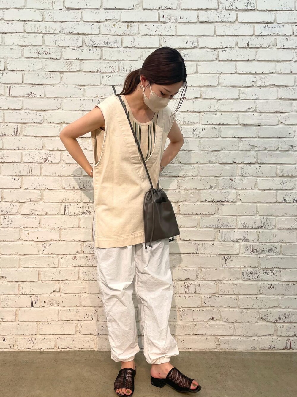 ホワイト系のベスト、グリーン系のタンクトップ、ホワイト系のその他パンツを着用したレディースの夏コーディネートの3枚目の写真