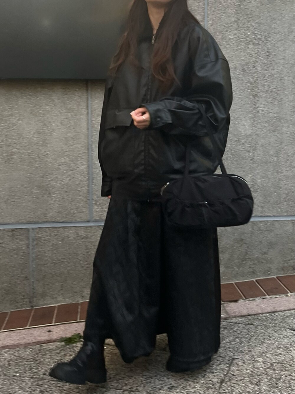 ブラック系のトートバッグ、ブラック系のブルゾン、ブラック系のワンピースを着用したレディースの冬コーディネートの2枚目の写真