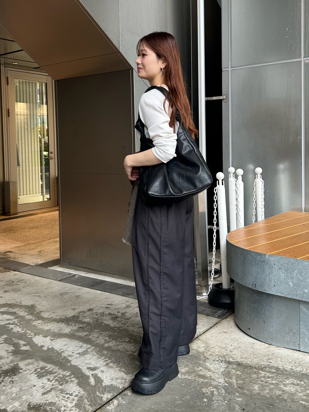 ブラック系のトートバッグを着用したレディースの夏コーディネートの2枚目の写真