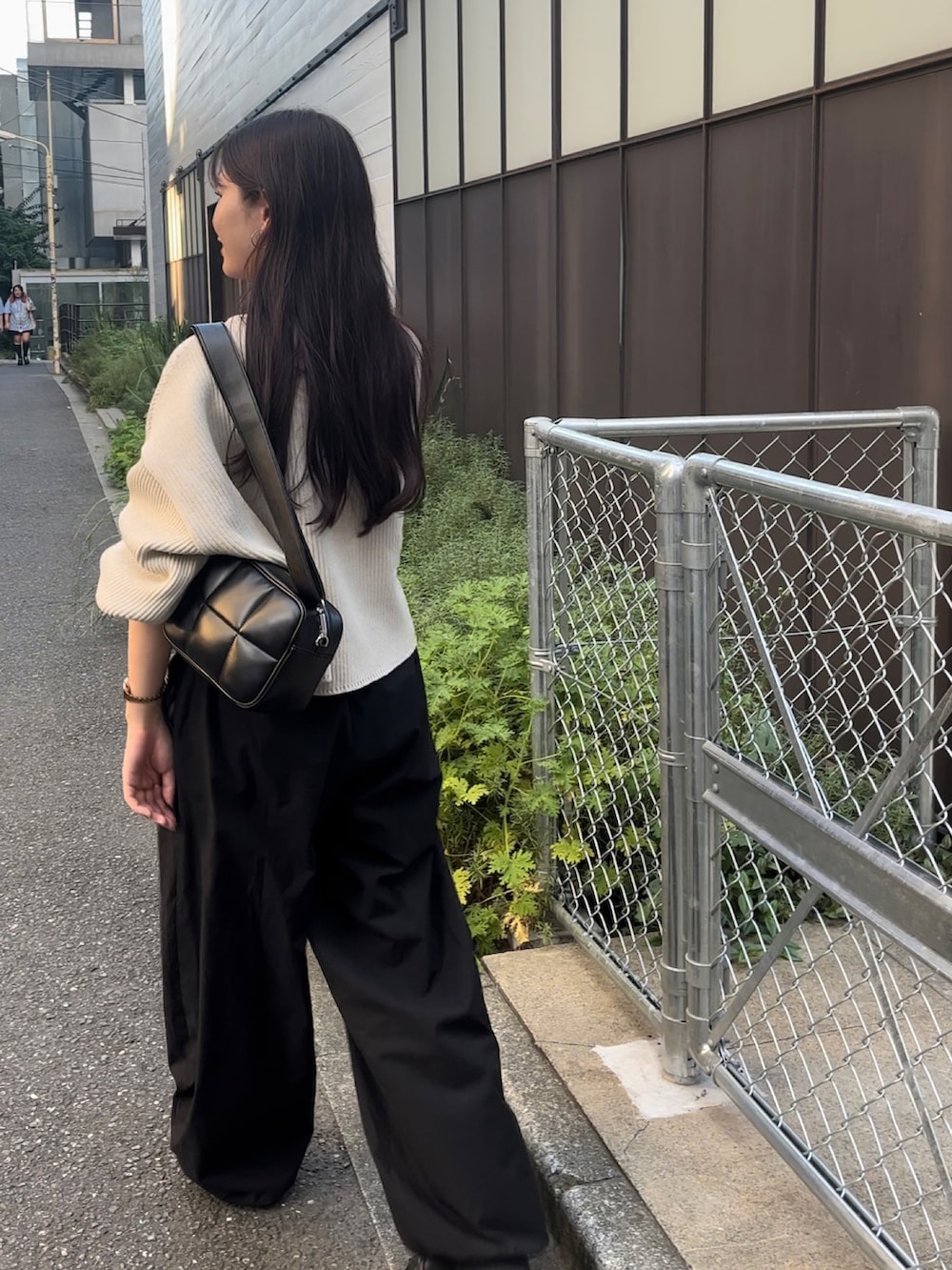 ブラック系のショルダーバッグ、ホワイト系のニット/セーター、ブラック系のカーゴパンツを着用したレディースの秋コーディネートの2枚目の写真