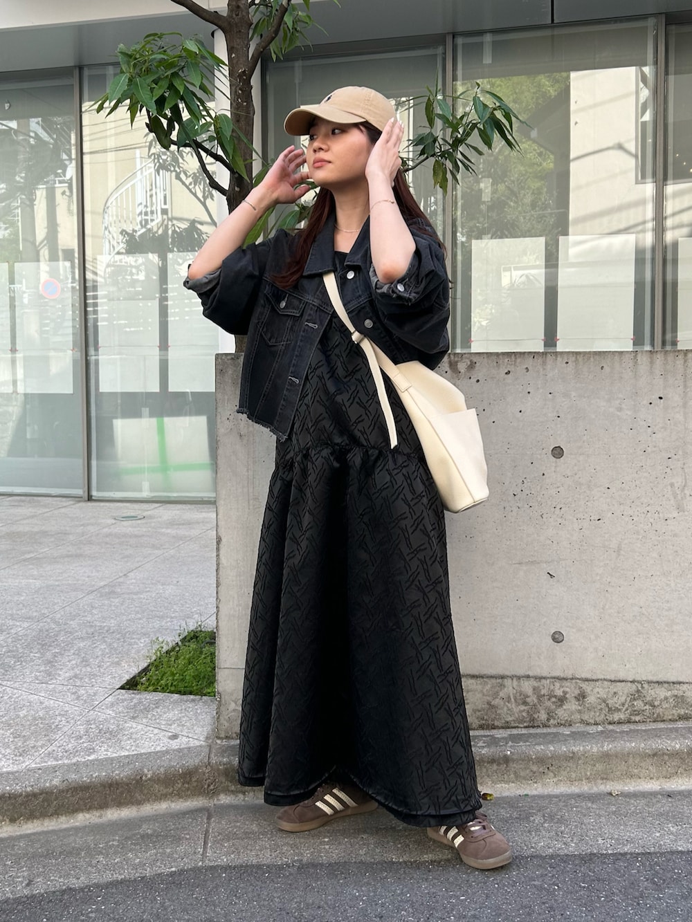 ホワイト系のショルダーバッグ、ブラック系のデニムジャケット、ブラック系のワンピースを着用したレディースの春コーディネートの4枚目の写真