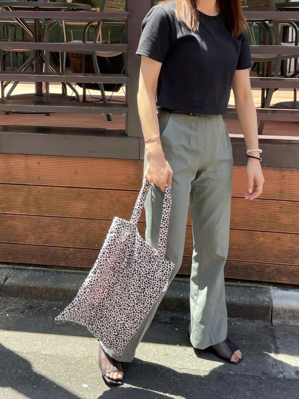 ホワイト系のエコバッグ/サブバッグ、ブラック系のTシャツ/カットソー、グリーン系のスラックスを着用したレディースの夏コーディネートの2枚目の写真