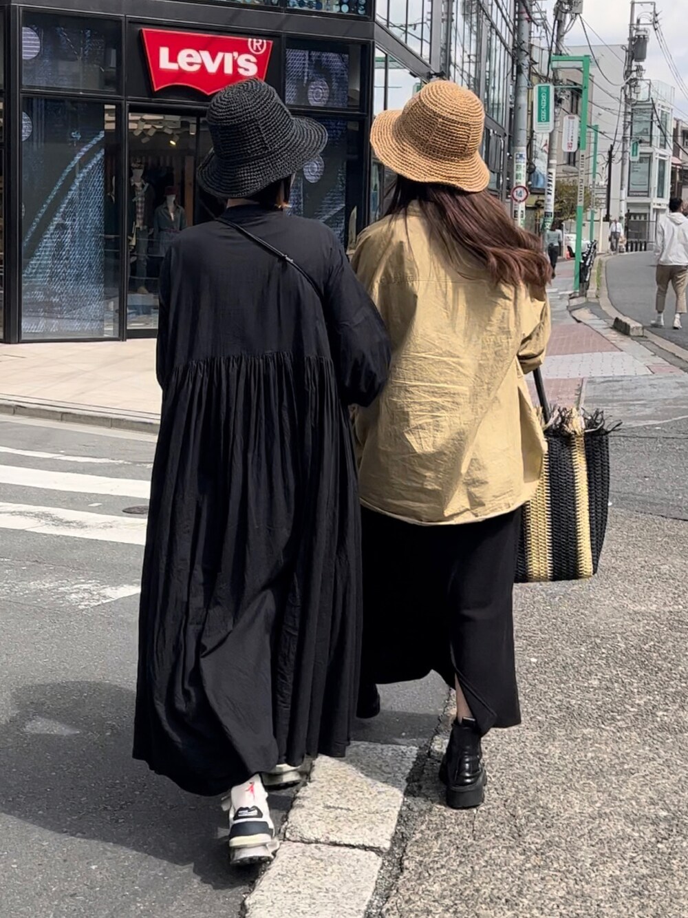 ブラック系のトートバッグ、ベージュ系のシャツ/ブラウス、ブラック系のワンピースを着用したレディースの春コーディネートの2枚目の写真