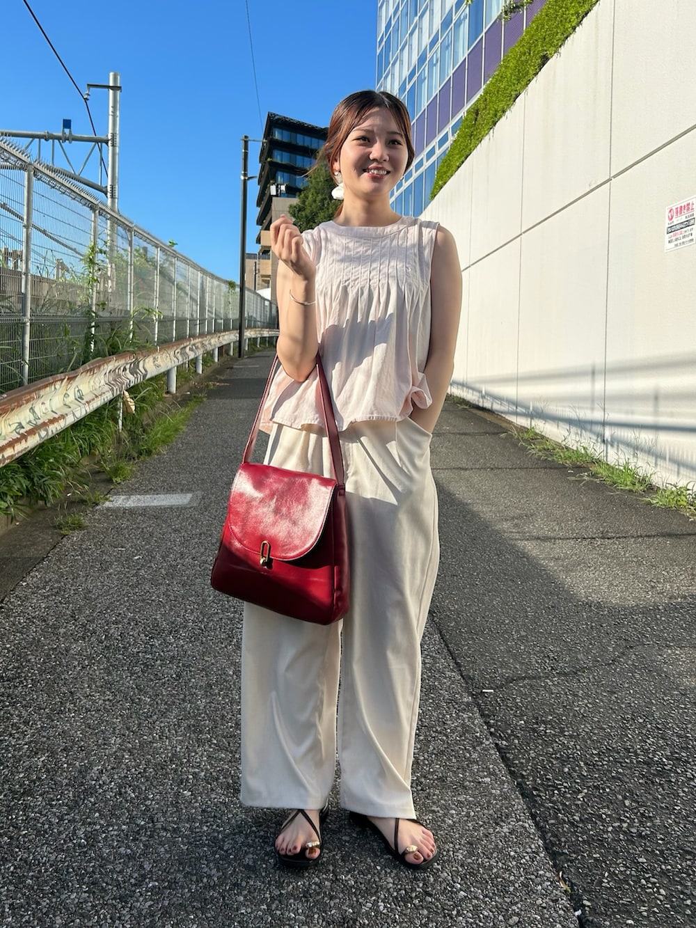 レッド系のトートバッグを着用したレディースの夏コーディネートの3枚目の写真