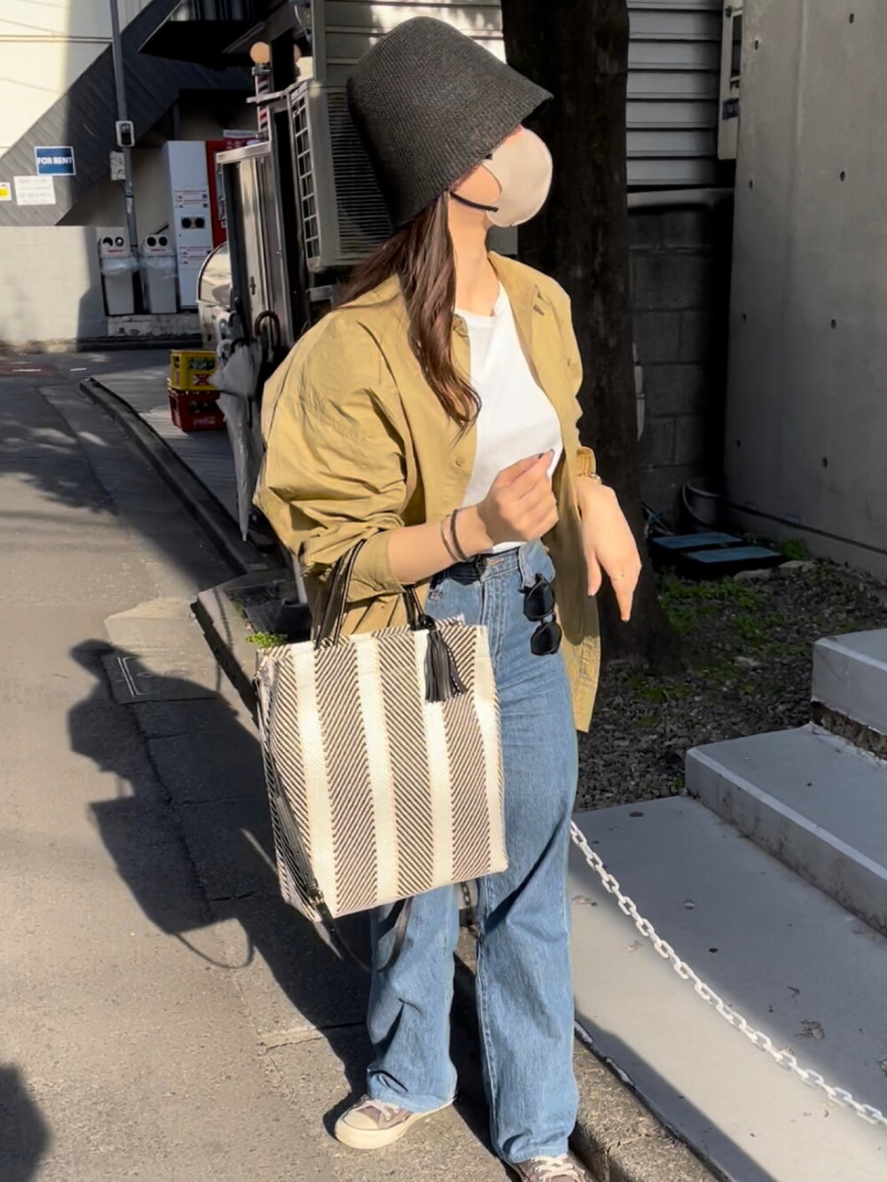 ブラック系のトートバッグ、ベージュ系のシャツ/ブラウス、ホワイト系のTシャツ/カットソーを着用したレディースの冬コーディネートの2枚目の写真