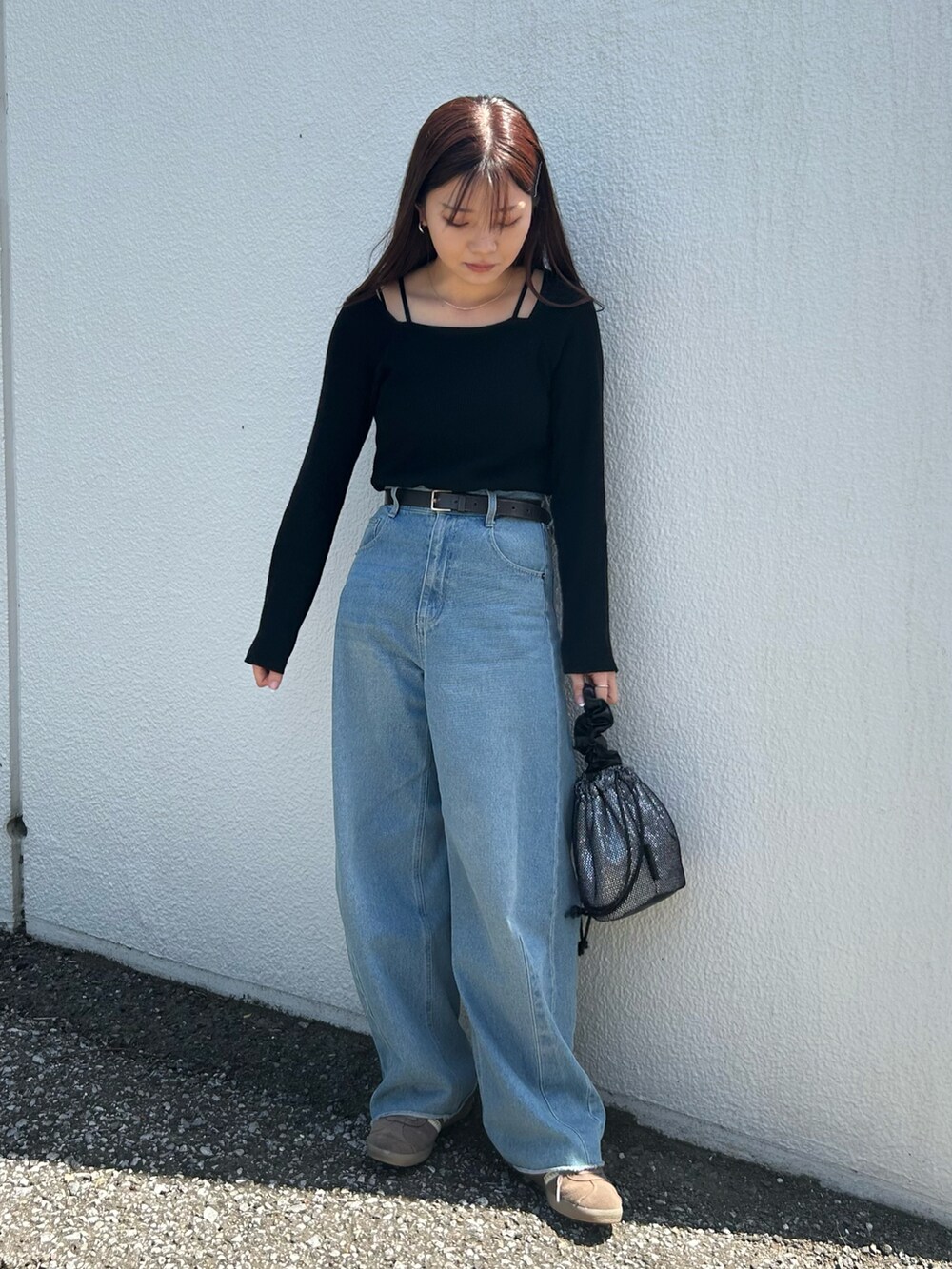 シルバー系のトートバッグ、ブラック系のニット/セーター、ブルー系のデニムパンツを着用したレディースの春コーディネートの3枚目の写真