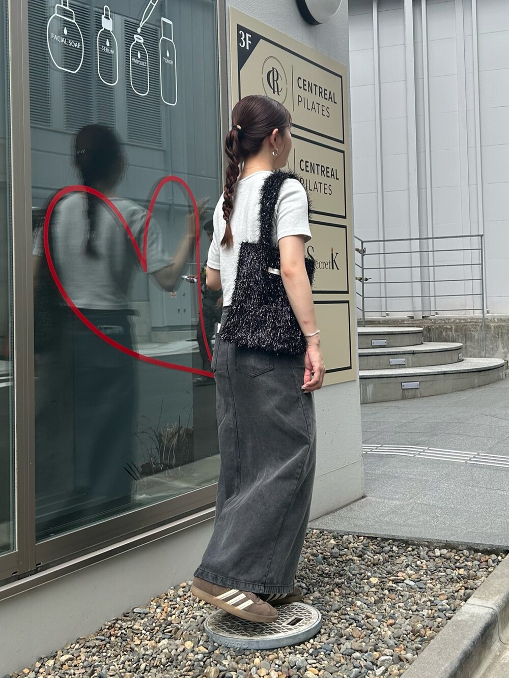 ブラック系のトートバッグ、グレー系のTシャツ/カットソー、ブラック系のデニムスカートを着用したレディースの秋コーディネートの2枚目の写真