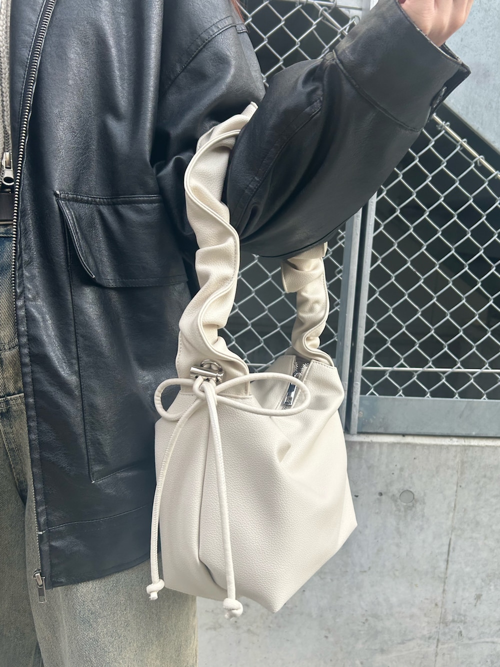 ホワイト系のトートバッグ、ブラック系のブルゾン、ホワイト系のニット/セーターを着用したレディースの冬コーディネートの4枚目の写真