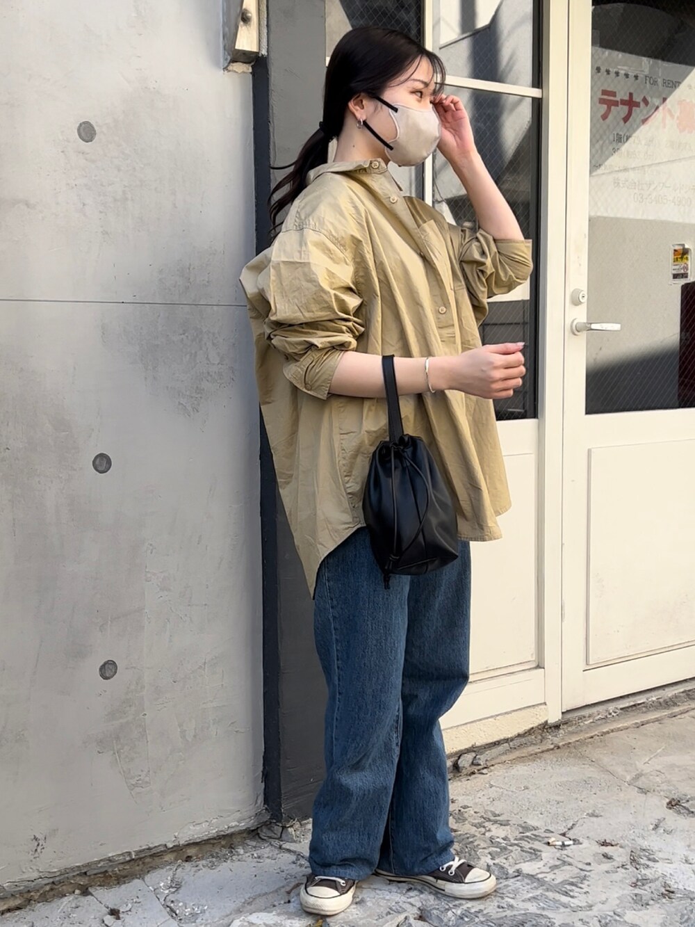 ブラック系のショルダーバッグ、ベージュ系のシャツ/ブラウス、ホワイト系のTシャツ/カットソーを着用したレディースの冬コーディネートの3枚目の写真