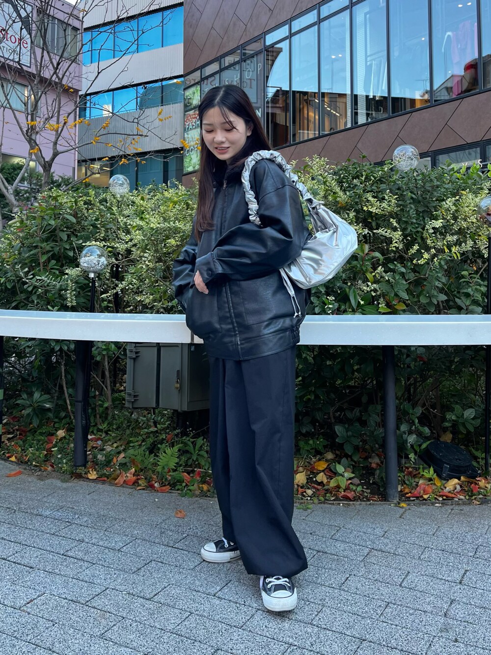 シルバー系のショルダーバッグ、ブラック系のブルゾン、ブラック系のカーゴパンツを着用したレディースの冬コーディネートの3枚目の写真